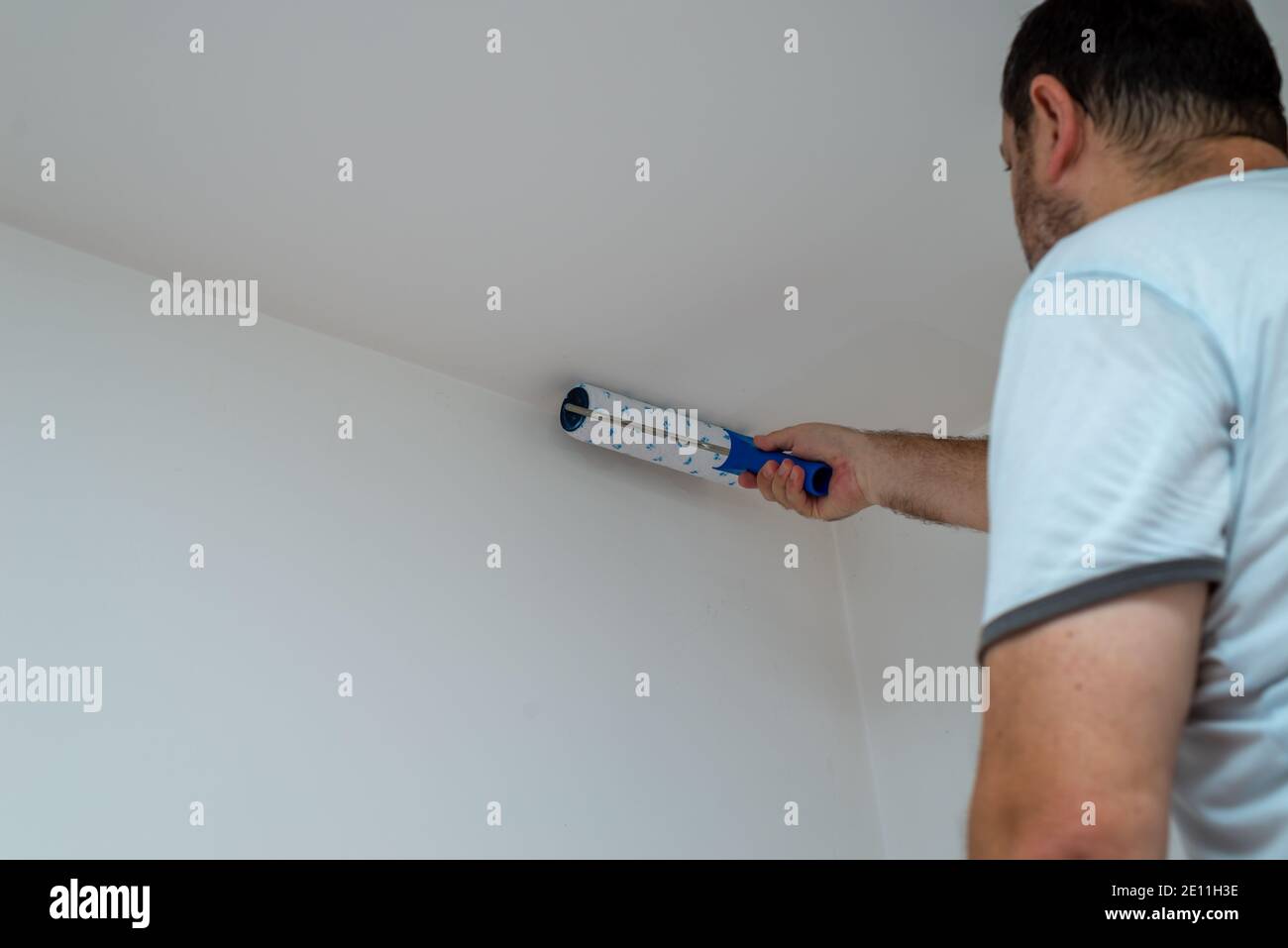 Man painting a ceiling in white color with a roller Stock Photo Alamy