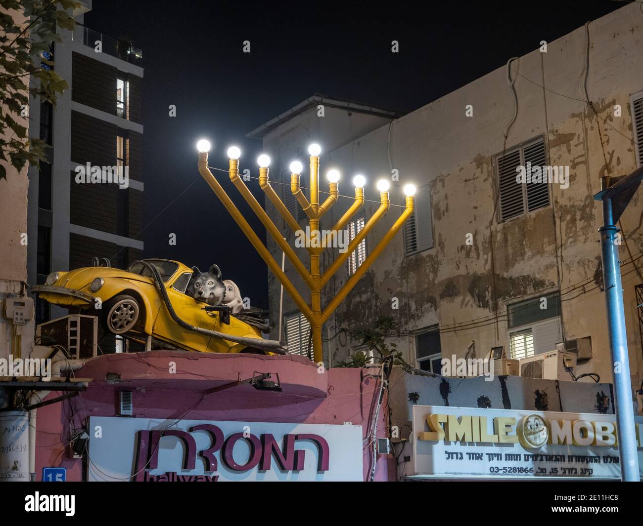 Bizarre scene of Hanukkah lamp as a city decorative statue with amusing yellow opened roof