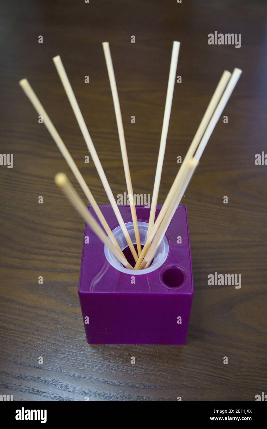 Aromatic reed air freshener on pink background hard shadow