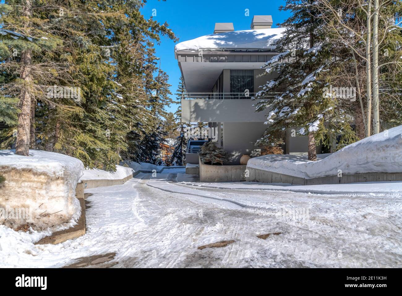 Snowy driveway in front of home in Park City Utah viewed on a sunny winter day Stock Photo
