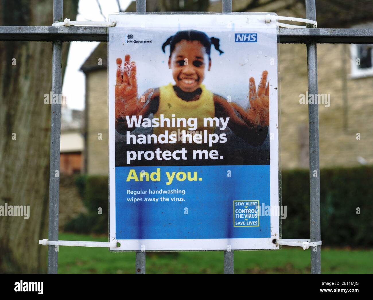 Signs advising on coronavirus spread and management attached to a school gate. 'Stop the spread' 'We're all responsible'. 'Walking hands'. Stock Photo