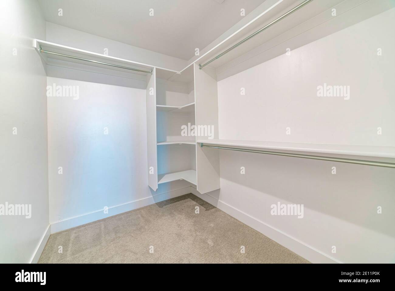 Interior of a walk in closet with shelves and clothes rod mounted on ...