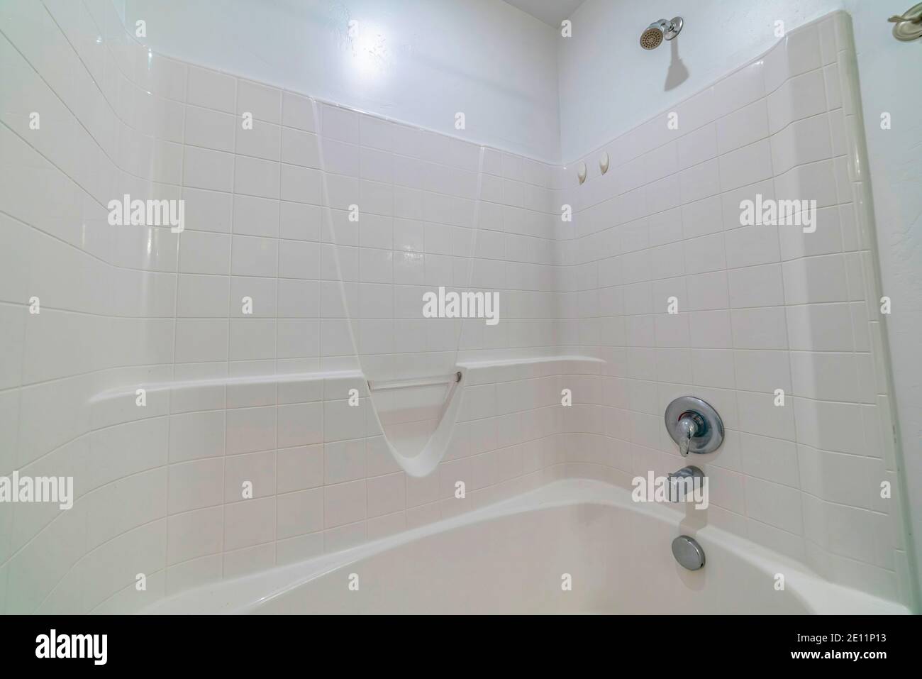 Stainless steel shower fixture and polished built in bathtub inside