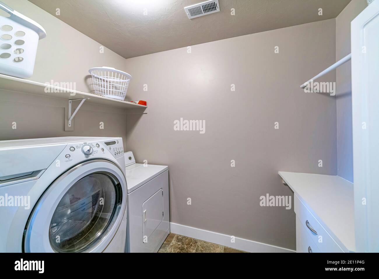 Laundry room of house with appliances storage bins wall shelf rod