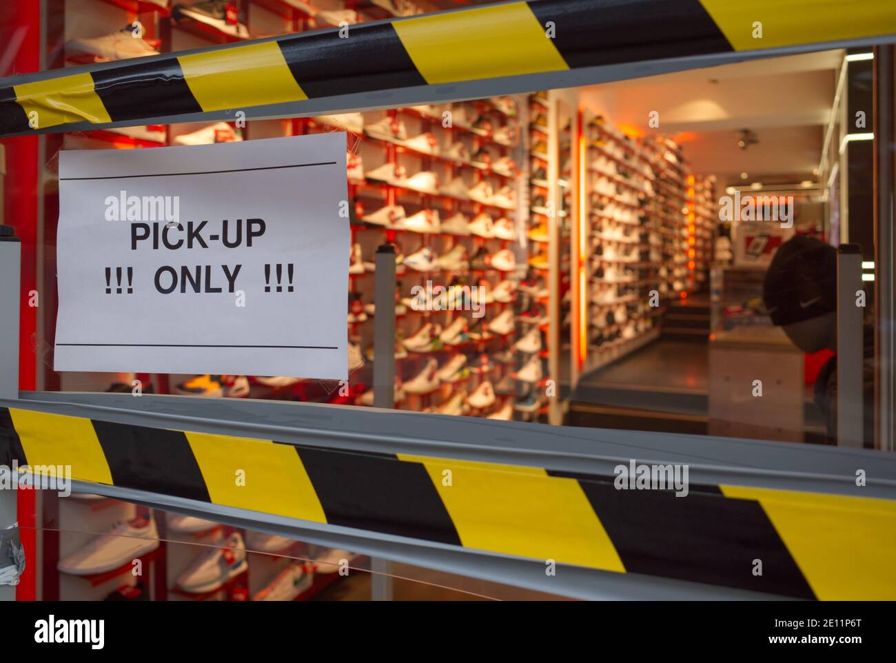 " Pickup only " sign on storefront of sneaker store which closed