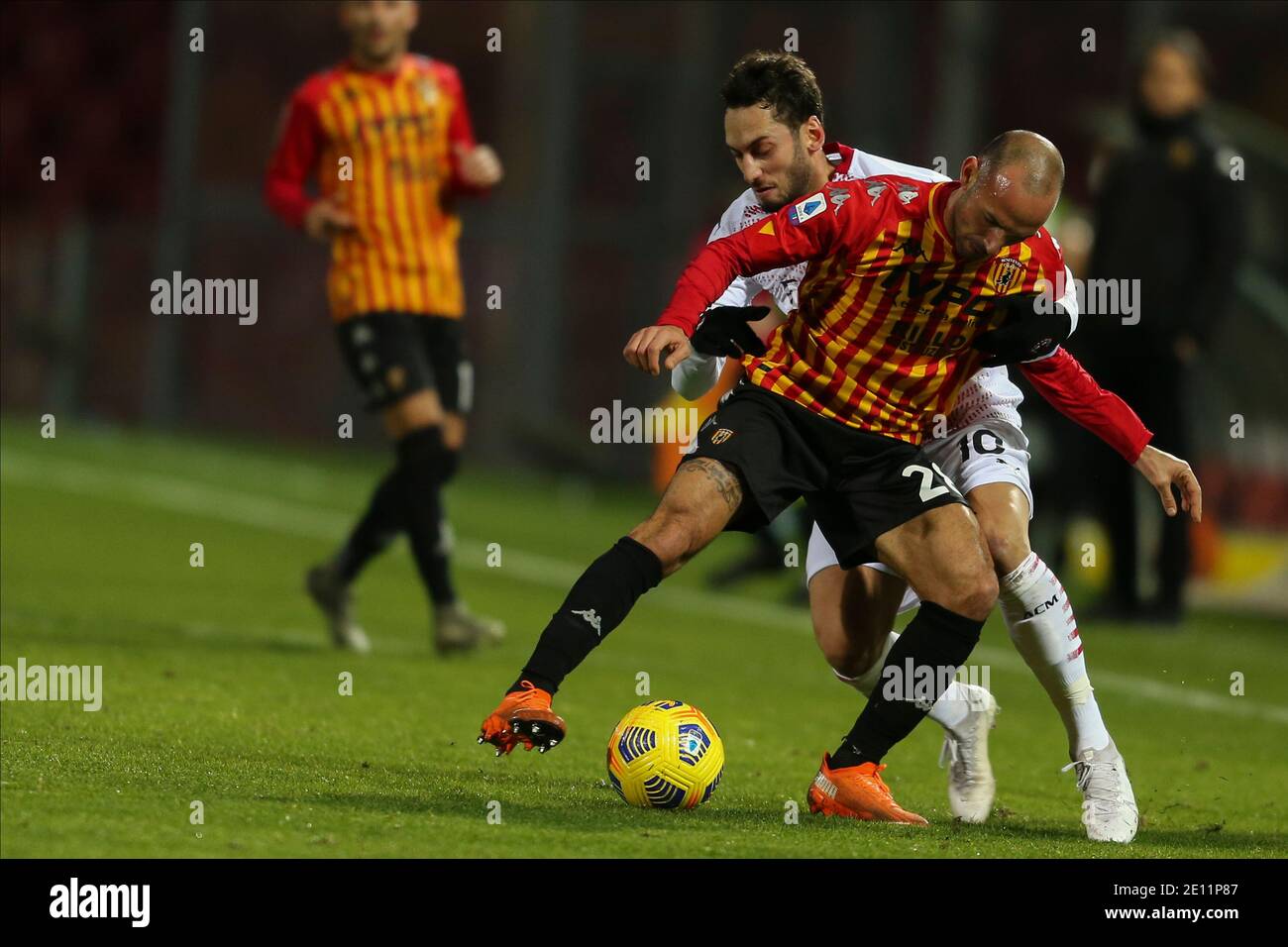 Milan’s Turkish midfielder Hakan Calhanoglu (L) challenges for the ball with Benevento's Italian midlefer Pasquale Schiattarella during the Serie A  football match Benevento vs  Ac Milan Stock Photo