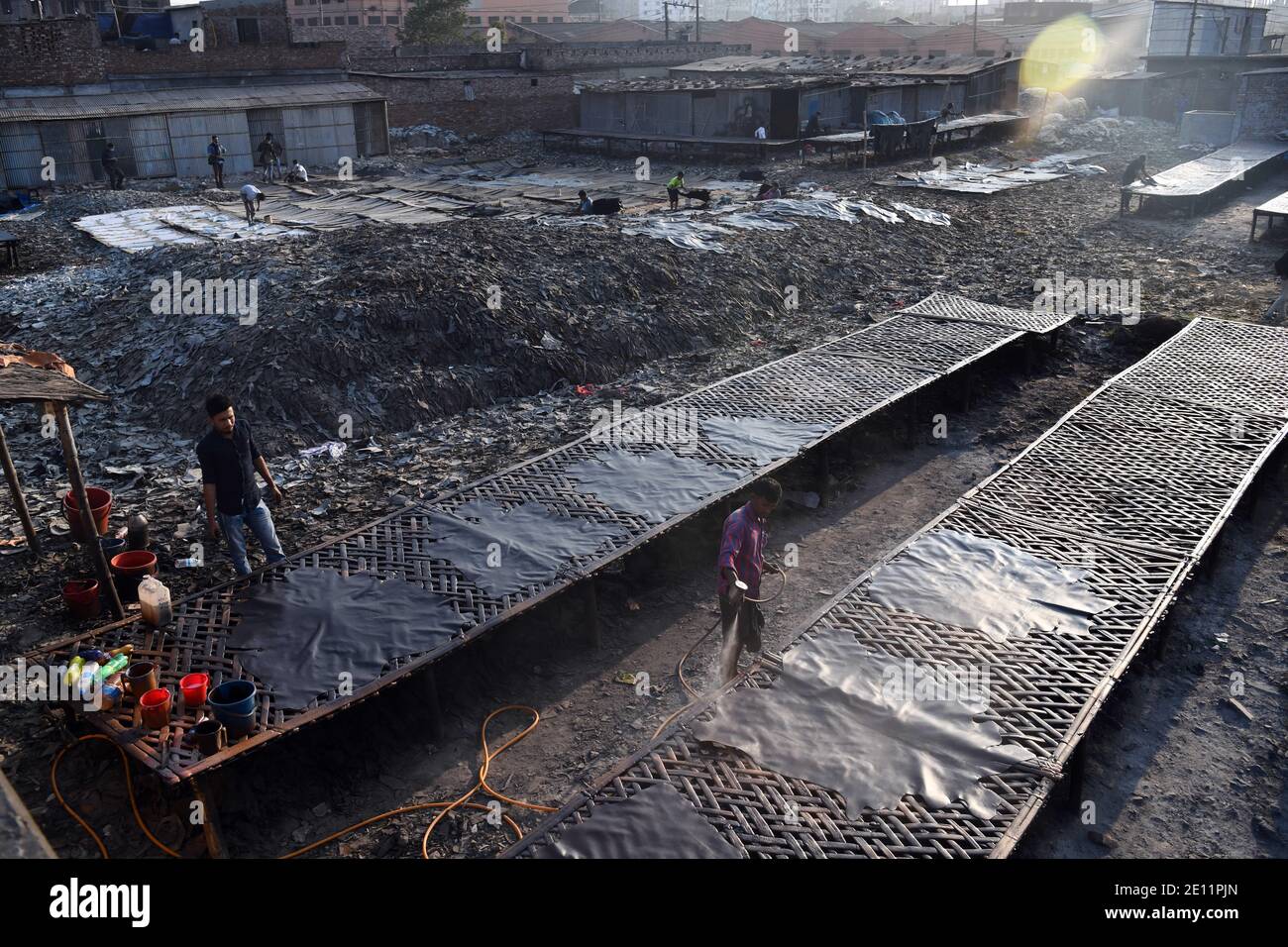 Labourers working at a tannery factory in Hazaribagh.Due to the presence of toxic chemicals, mainly chromium. The tannery industry pollutes with smoke from its waste the air of Hazaribagh. Stock Photo