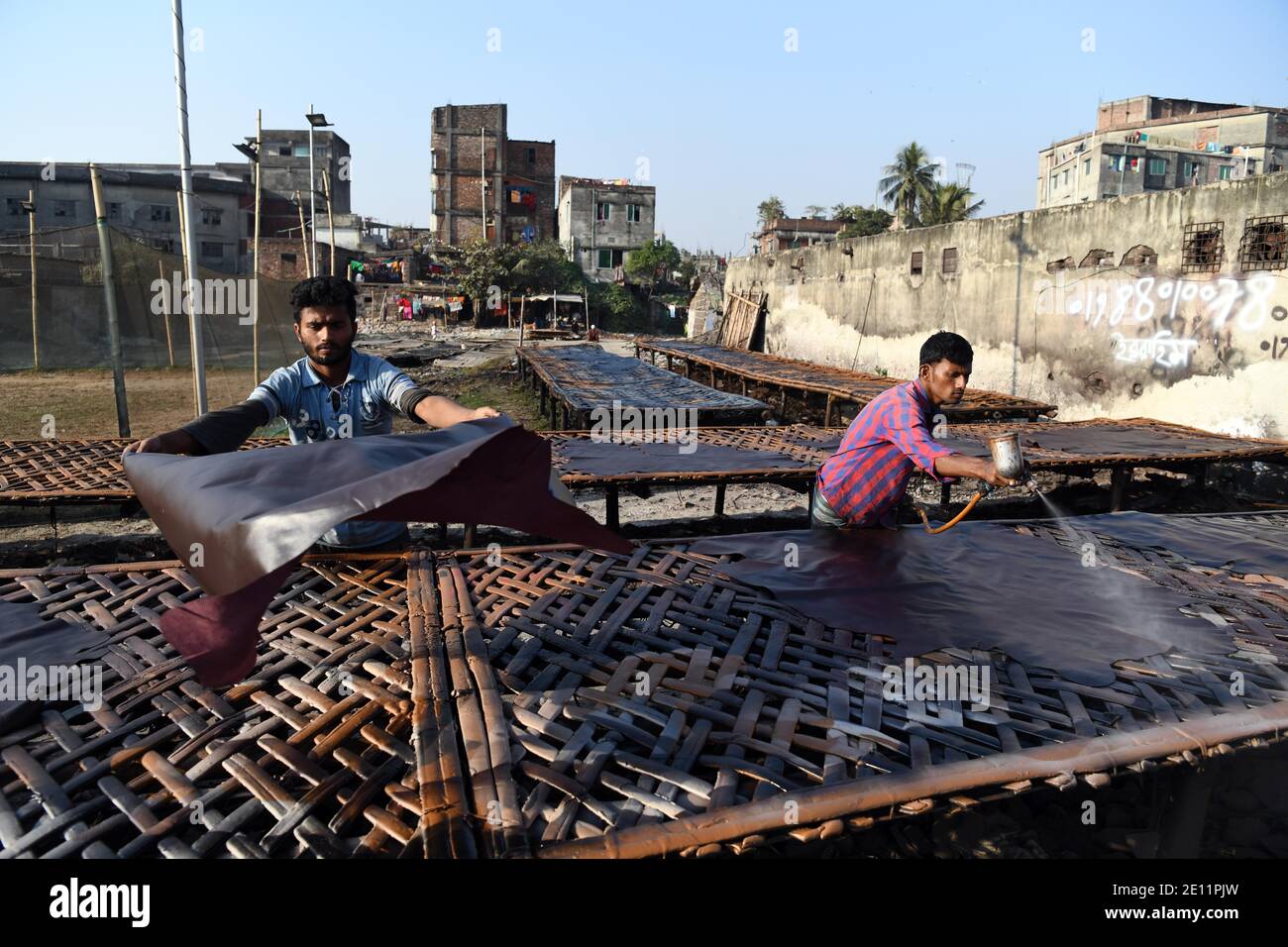 Labourers working at a tannery factory in Hazaribagh.Due to the presence of toxic chemicals, mainly chromium. The tannery industry pollutes with smoke from its waste the air of Hazaribagh. Stock Photo