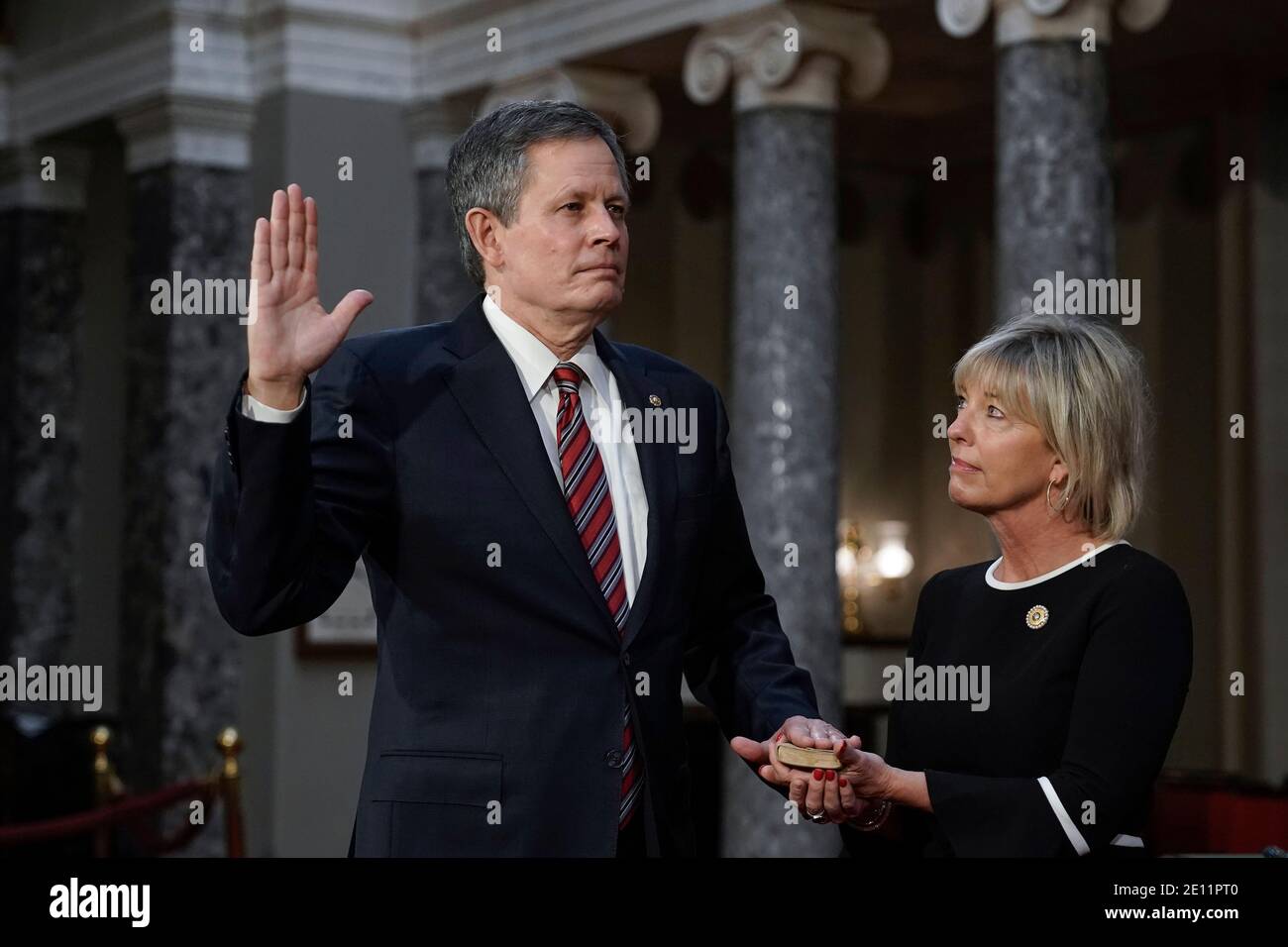 Washington, USA. 03rd Jan, 2021. Sen. Steve Daines, R-Mont., joined by his wife Cindy Daines, raises his hand to take the oath of office from Vice President Mike Pence during a reenactment ceremony in the Old Senate Chamber at the Capitol in Washington, Sunday, Jan. 3, 2021. (Photo by J. Scott Applewhite/Pool/Sipa USA) Credit: Sipa USA/Alamy Live News Stock Photo