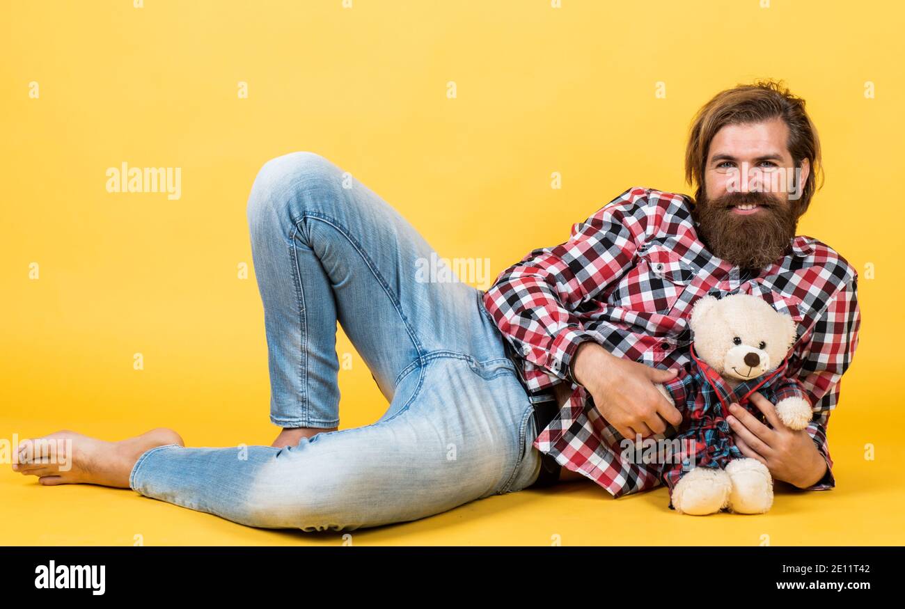 relaxation and joy. happy birthday. being in good mood. happy valentines day. cheerful bearded man hold teddy bear. male feel playful with bear. brutal mature hipster man play with toy. Stock Photo