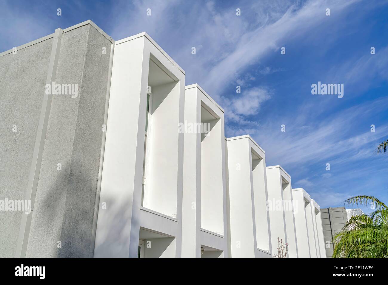 Modern townhome facade with flat roof and projecting window frames ...