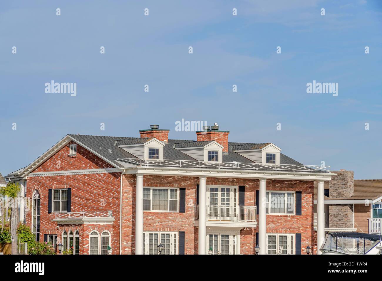 House with red brick wall gable roof dormers and balcony in Huntington Beach  CA Stock Photo - Alamy, image size:1300x957