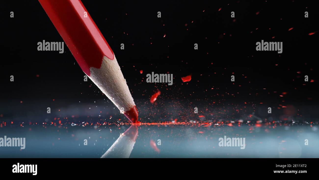 A red crayon damaged by pressure on glass while learning to draw or color Stock Photo