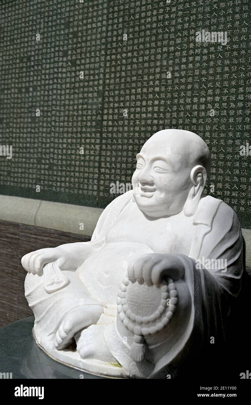 Stone sculpture of Budai or 'Laughing Buddha', a semi-historical Chinese monk who is venerated as Maitreya Buddha in Zen or Chan Buddhism Stock Photo