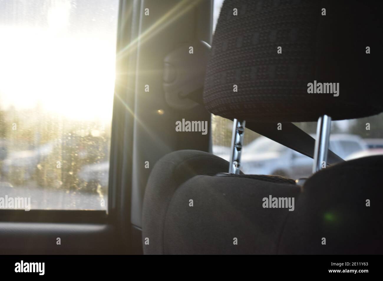 seat and seatbelt inside a car with the sun streaming through the window Stock Photo