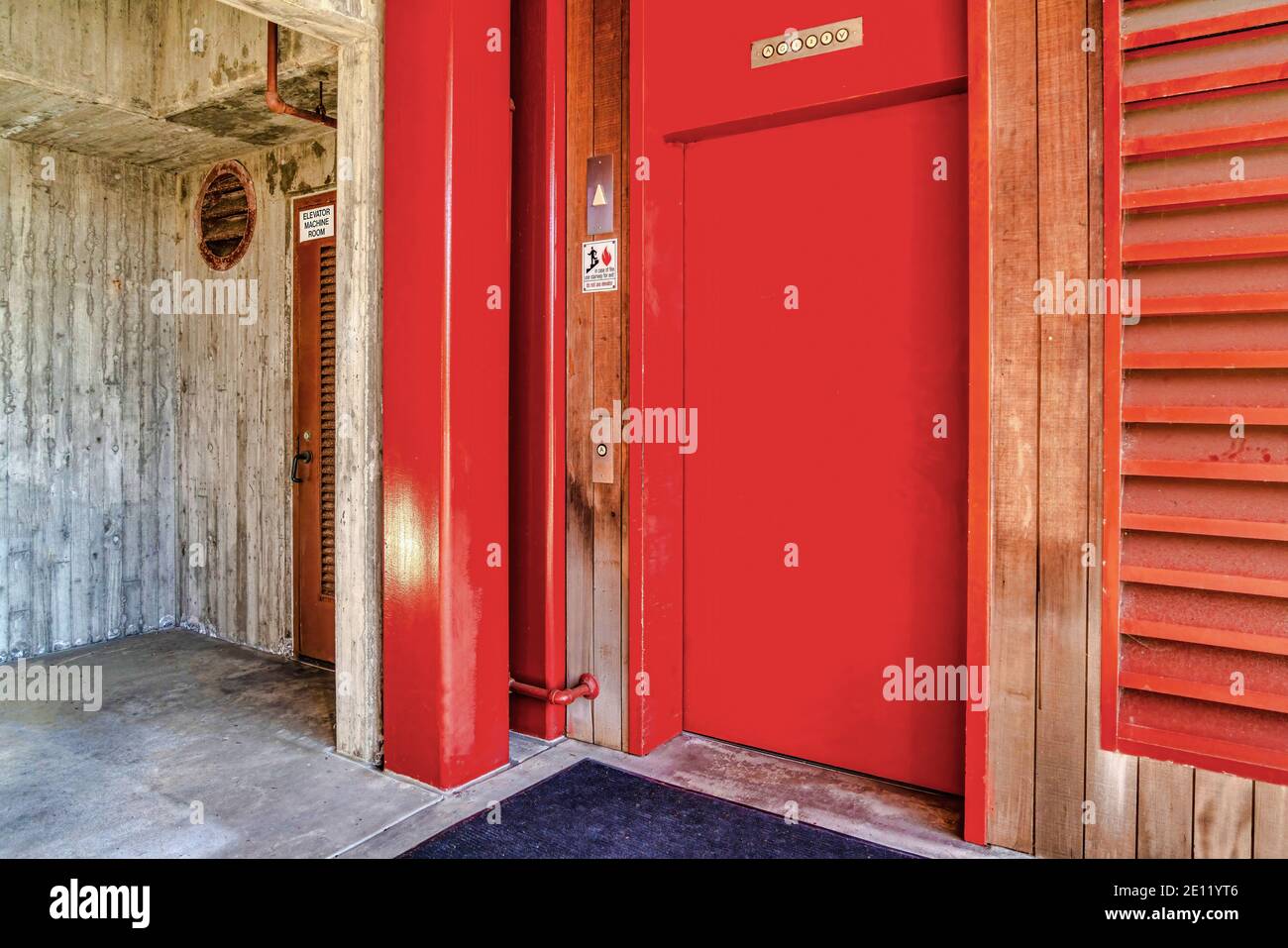 Vibrant red elevator door with buttons San Diego building exterior Stock Photo Alamy