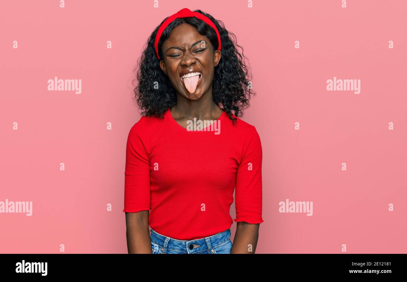 Beautiful african young woman wearing casual clothes sticking tongue ...
