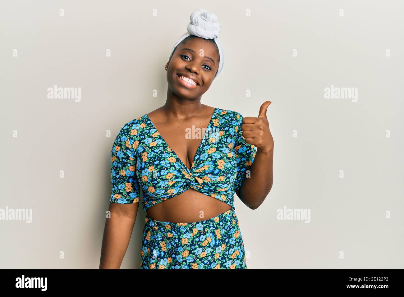 Young african woman wearing hair turban and african style smiling with ...