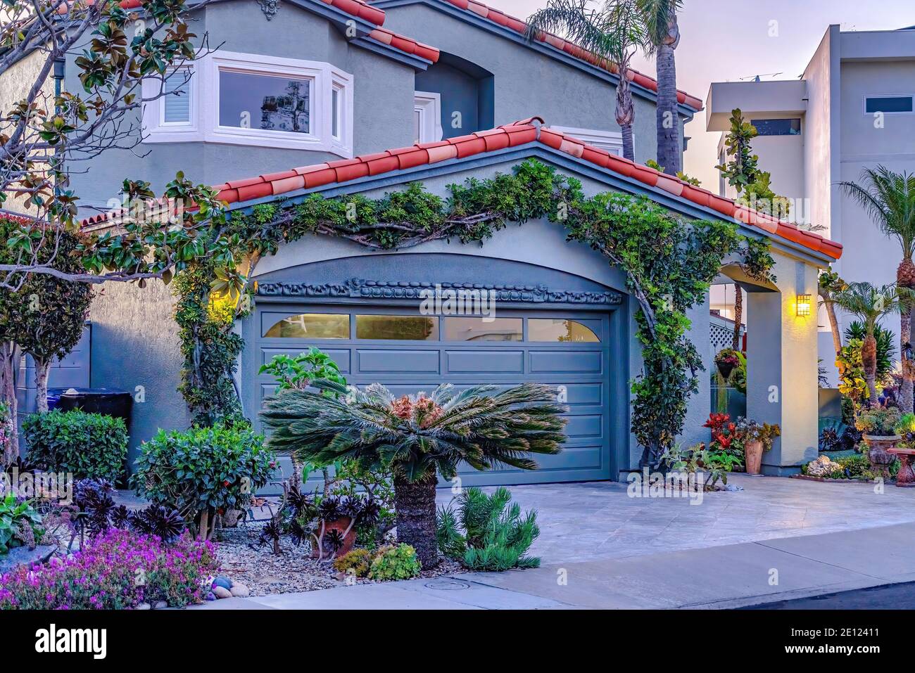 facade of gray house with bay window gable roof over garage and arched