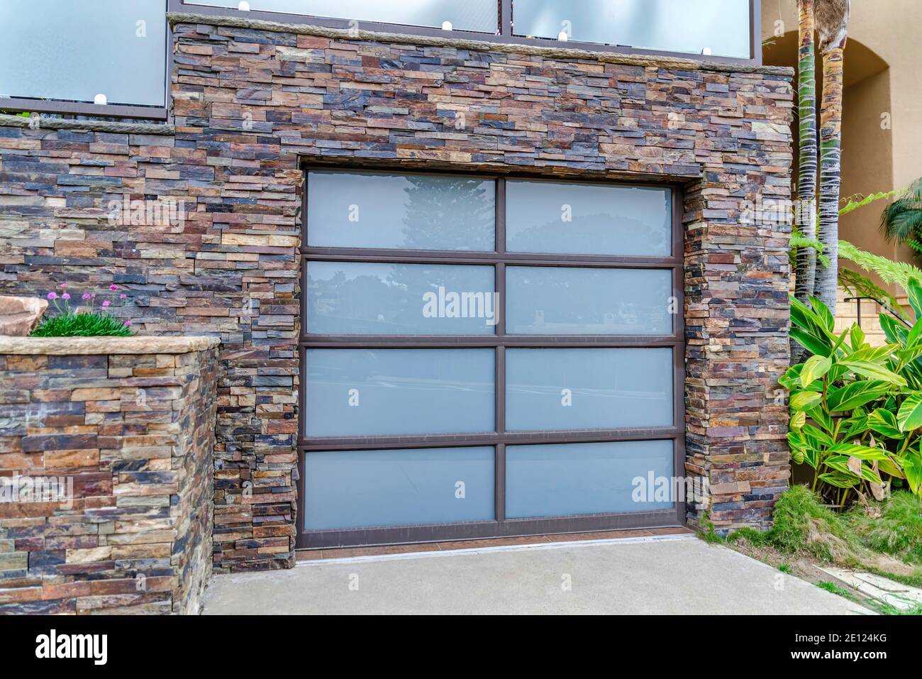 Glass paned garage door and stone brick wall of house in San Doego ...
