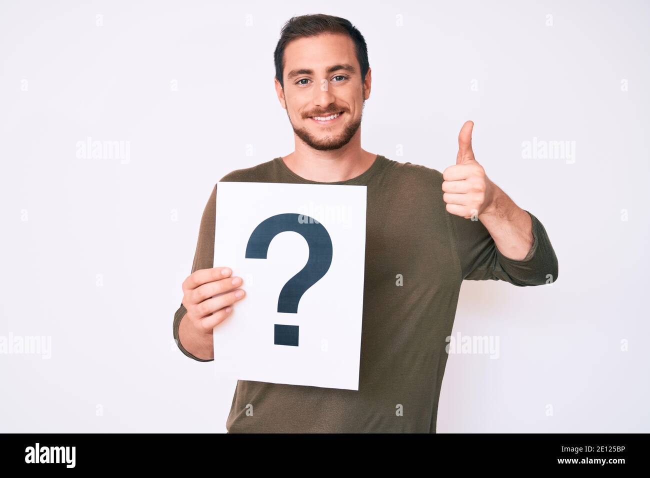 Young handsome man holding question mark smiling happy and positive ...