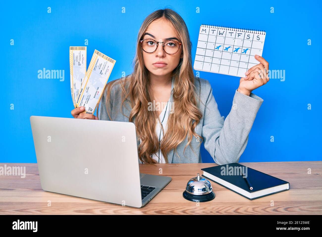 Young beautiful blonde woman holding boarding pass and travel calendar skeptic and nervous, frowning upset because of problem. negative person. Stock Photo