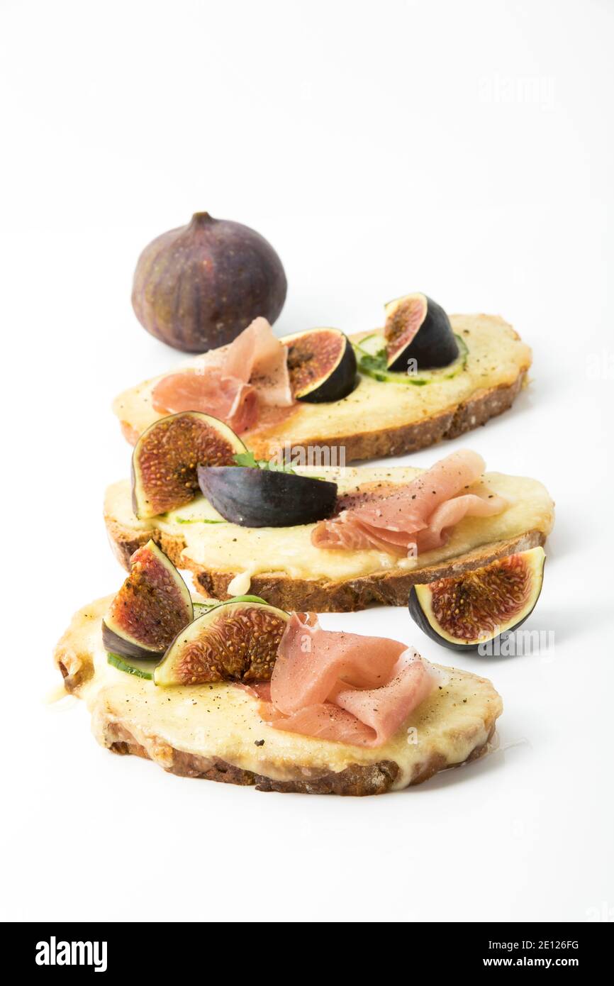 Baked Ham And Cheese Bread Topped With Figs, White Background, Top View Stock Photo