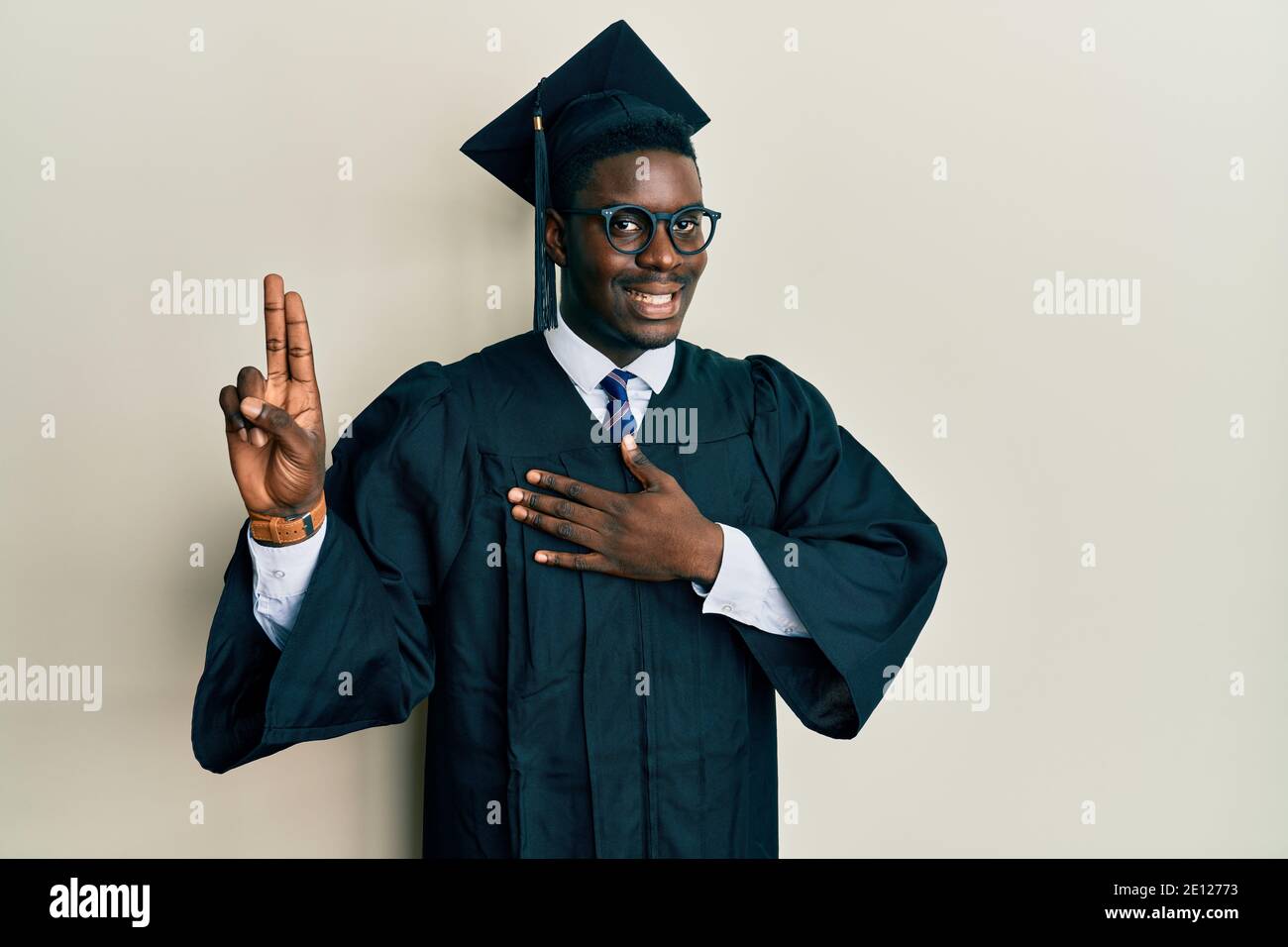 Handsome black man wearing graduation cap and ceremony robe