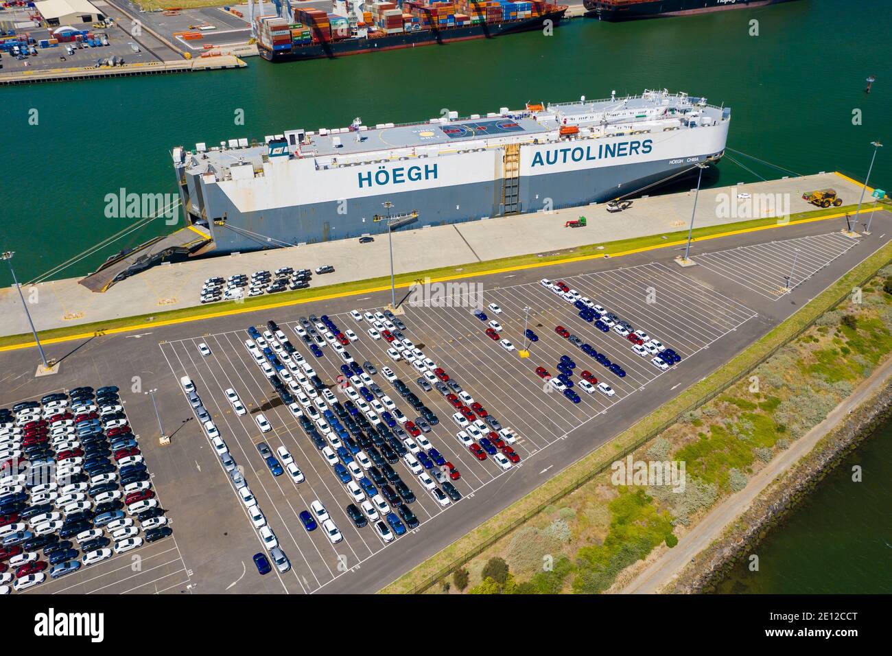 Aerial photo of vehicles waiting to be loaded onto car carrier at port Stock Photo