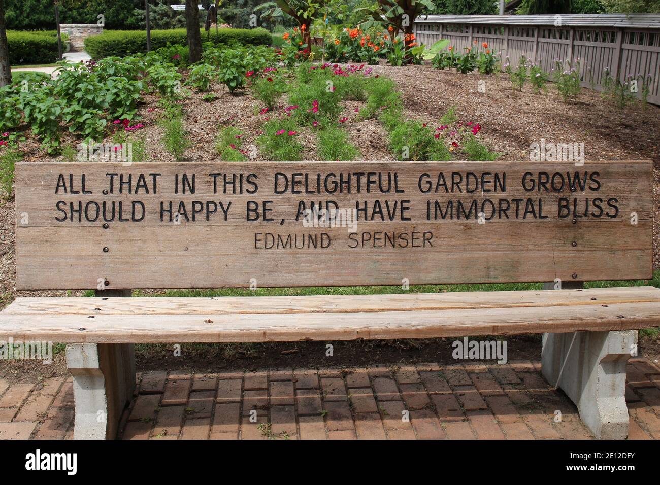 A park bench with an engraved quote by Edmund Spenser on a brick ...