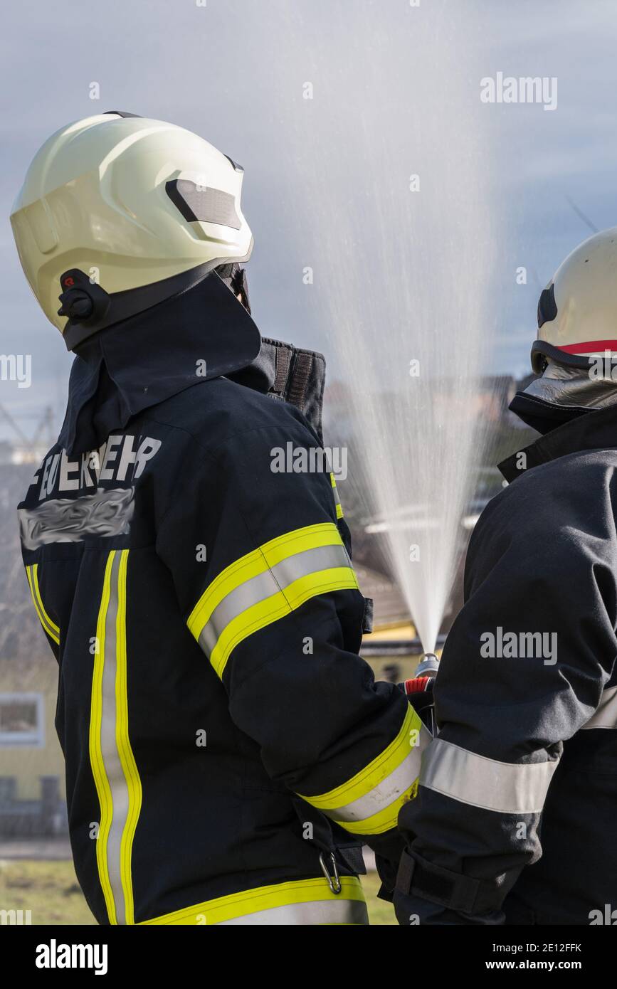 Firefighters In Safety Clothing With Pressure Hose - Fire Stock Photo