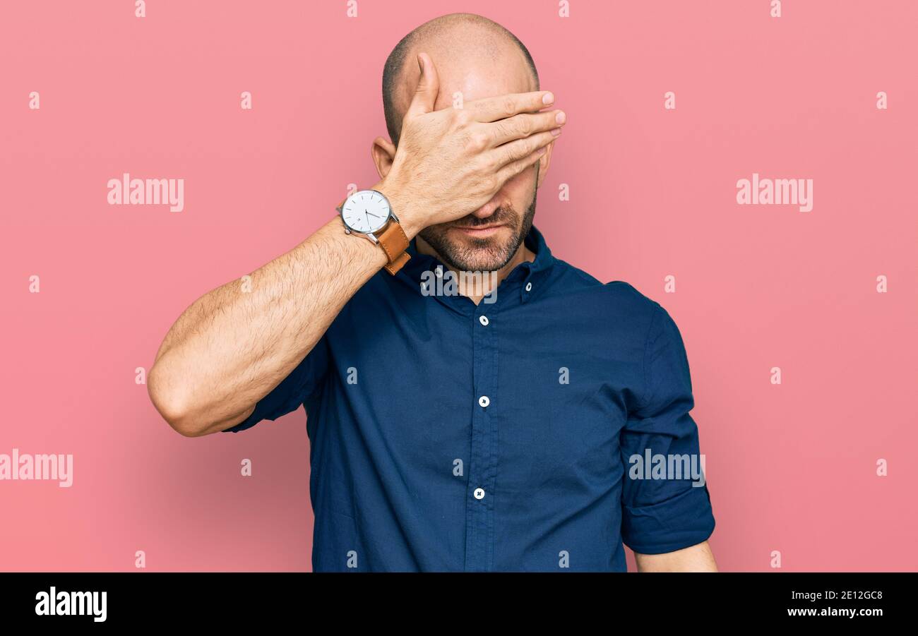 Young hispanic man wearing casual clothes covering eyes with hand ...