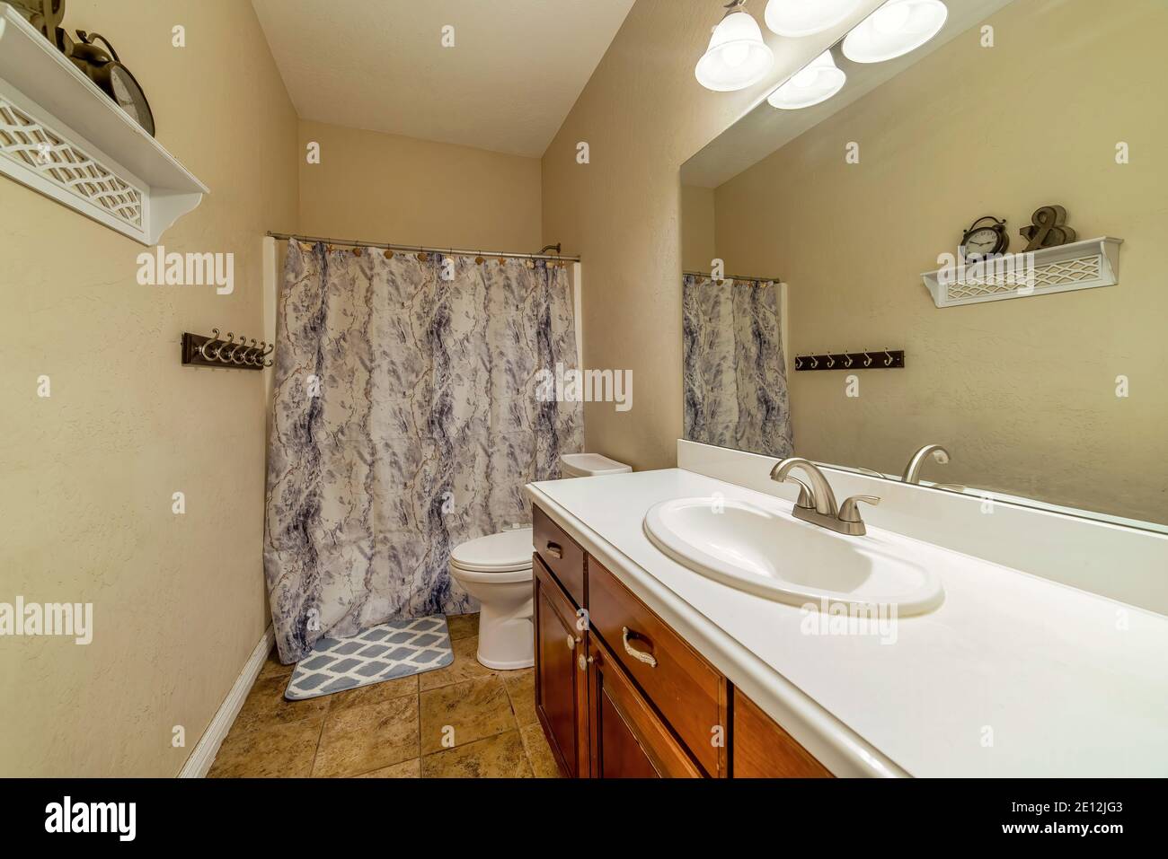 Residential bathroom design ideas with tile floor and printed shower curtain Stock Photo