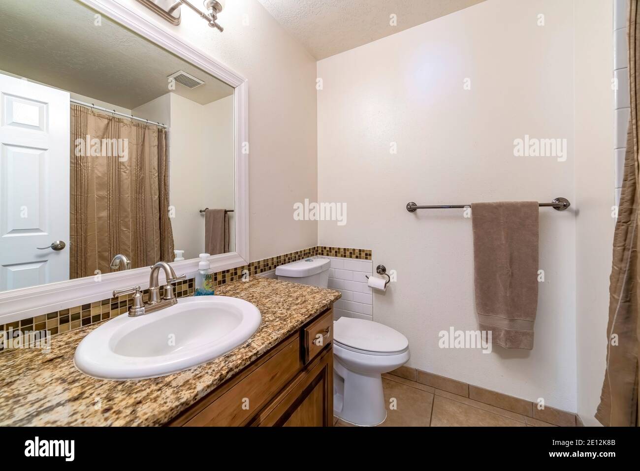 Sink on marble countertop and cabinet beside toilet of bathroom with ...
