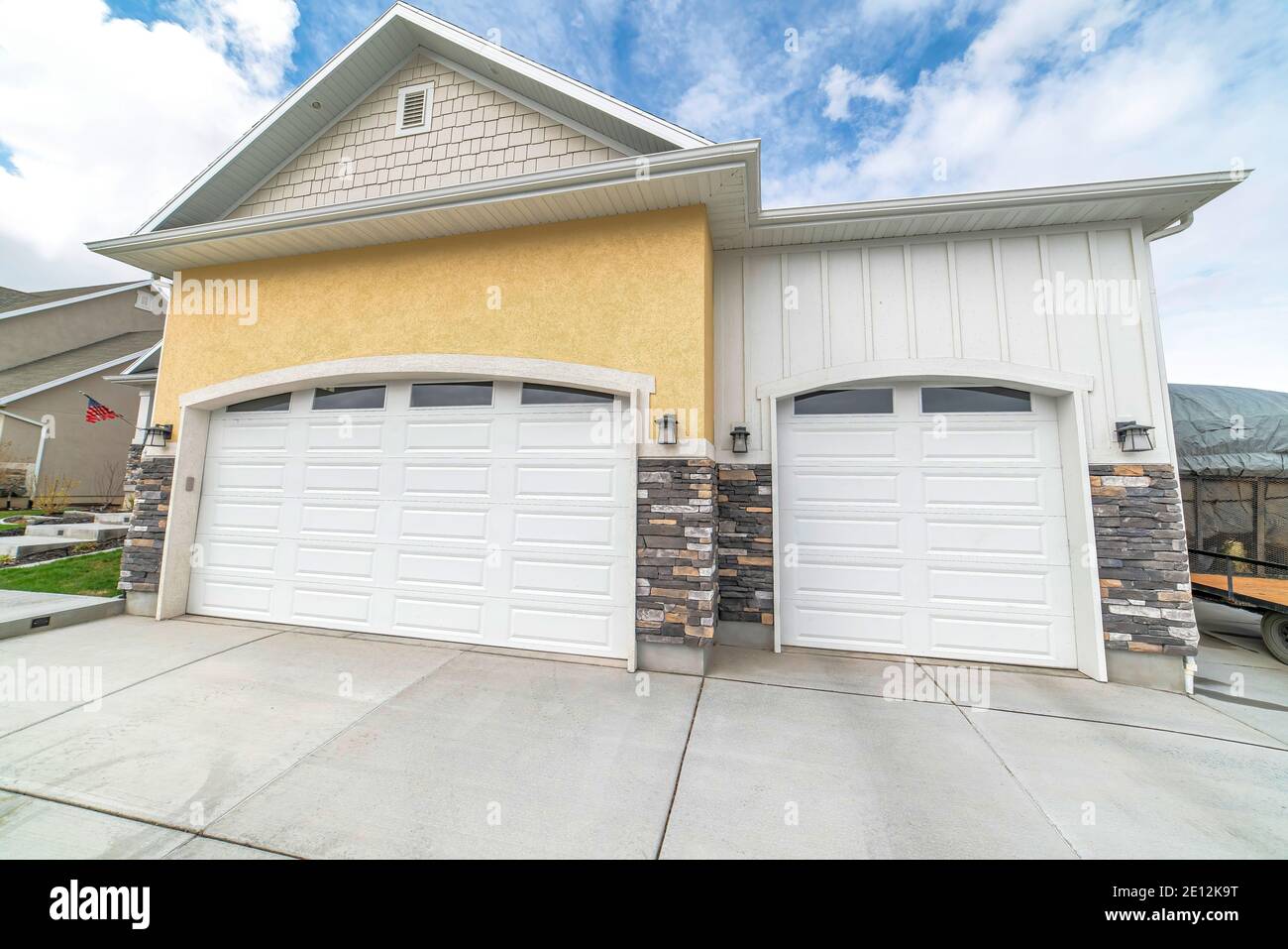 Facade of residential two car garage with gable roof and white panelled