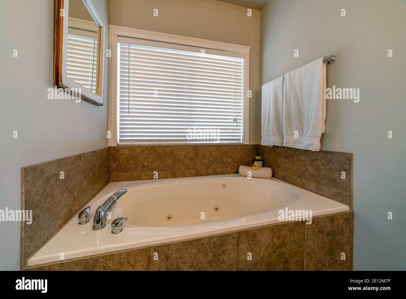 Round built in bathtub against window with blinds of bathroom of a ...