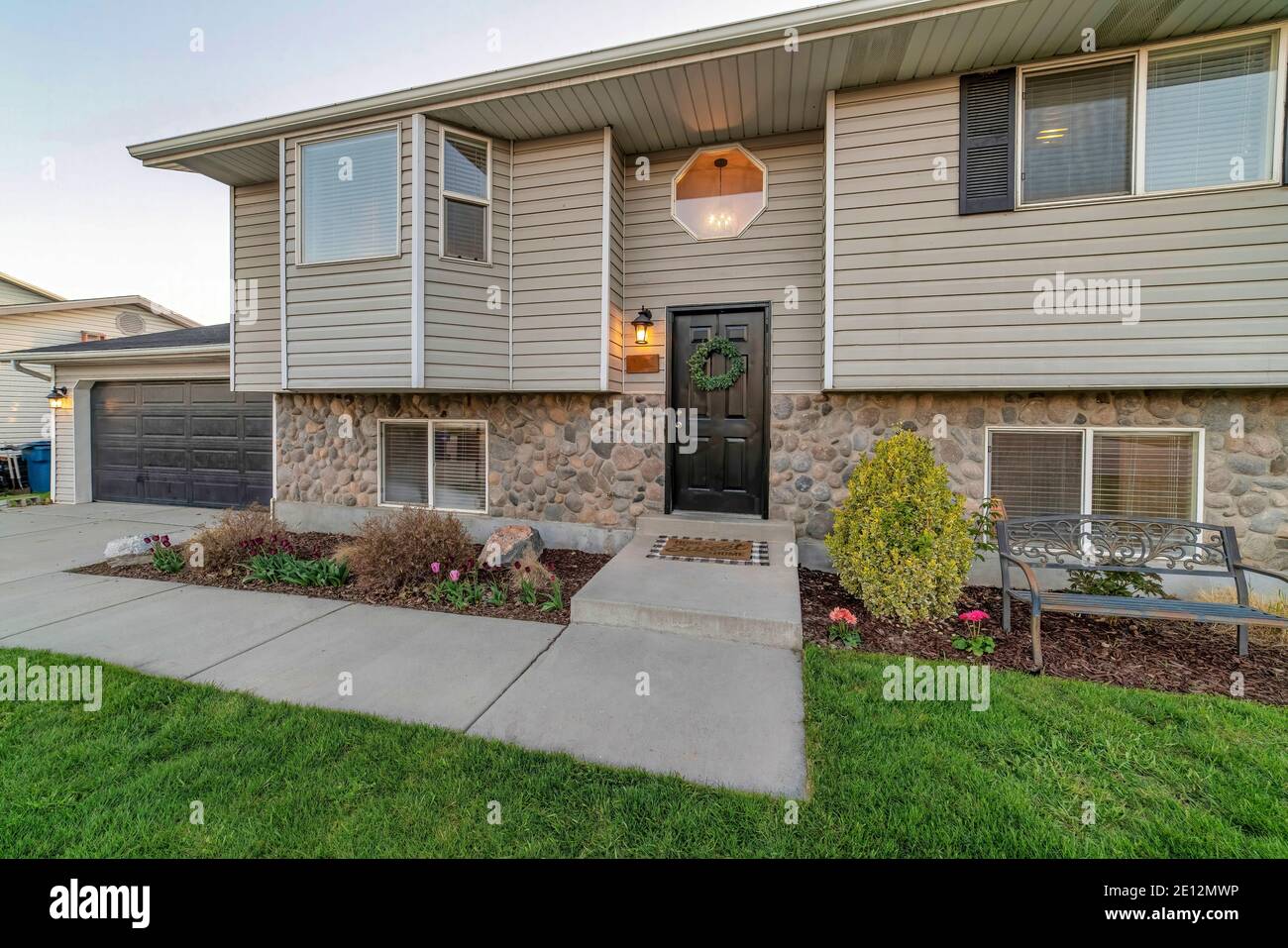 Two storey home exterior view with bay window black door and octagon