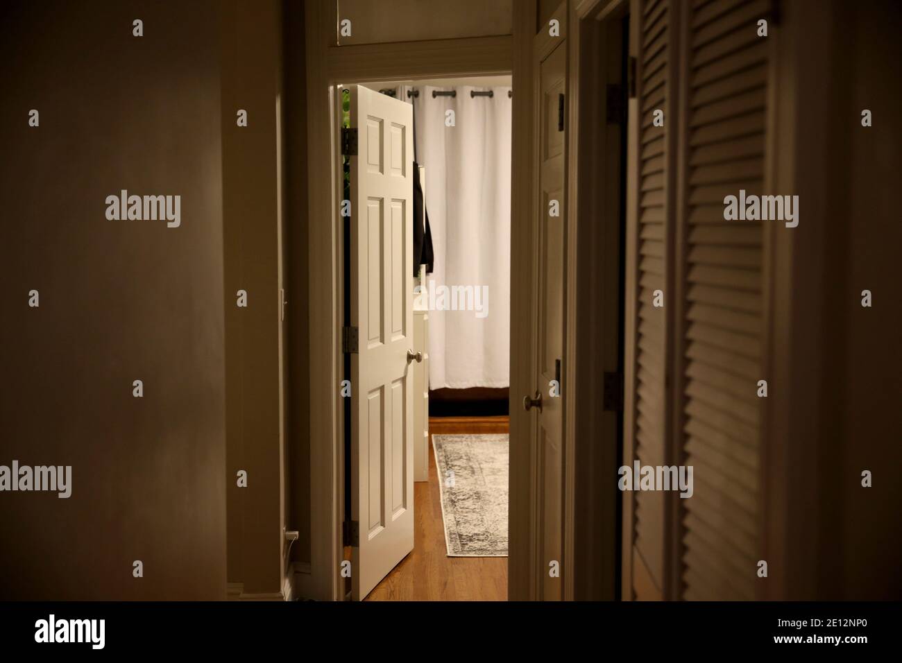 light from the open door to the dark corridor of the apartment. Interior empty house with wooden floor Stock Photo