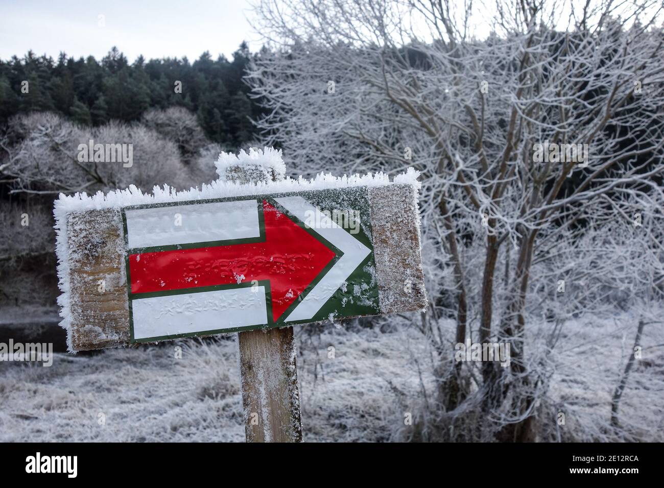 Tourist trail marking (trail blazing) in the Czech Republic. Painted red mark in winter covered in snow. Stock Photo
