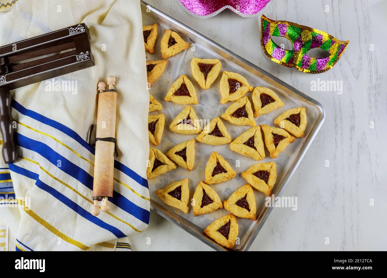 Jewish triangle cookies with jam for Purim with mask, tallit and noisemaker with tora Stock