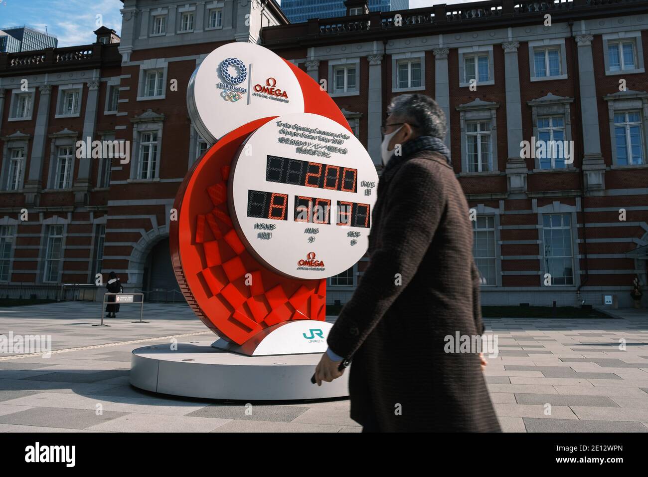 Pedestrian wearing protective facial masks walks by a Tokyo 2020 Olympic official clock indicating 200 days to go on January 04, 2020 in Tokyo Japan. Tokyo, JAPAN 4 January 2021. January 04, 2021 Credit: Nicolas Datiche/AFLO/Alamy Live News Stock Photo