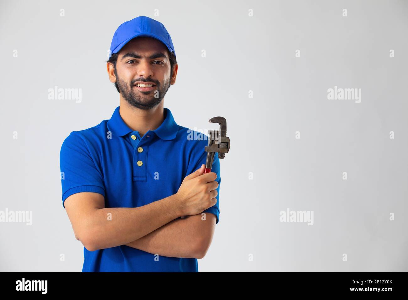 A PLUMBER SHOWING HIS EQUIPMENTS WHILE LOOKING AT CAMERA Stock Photo