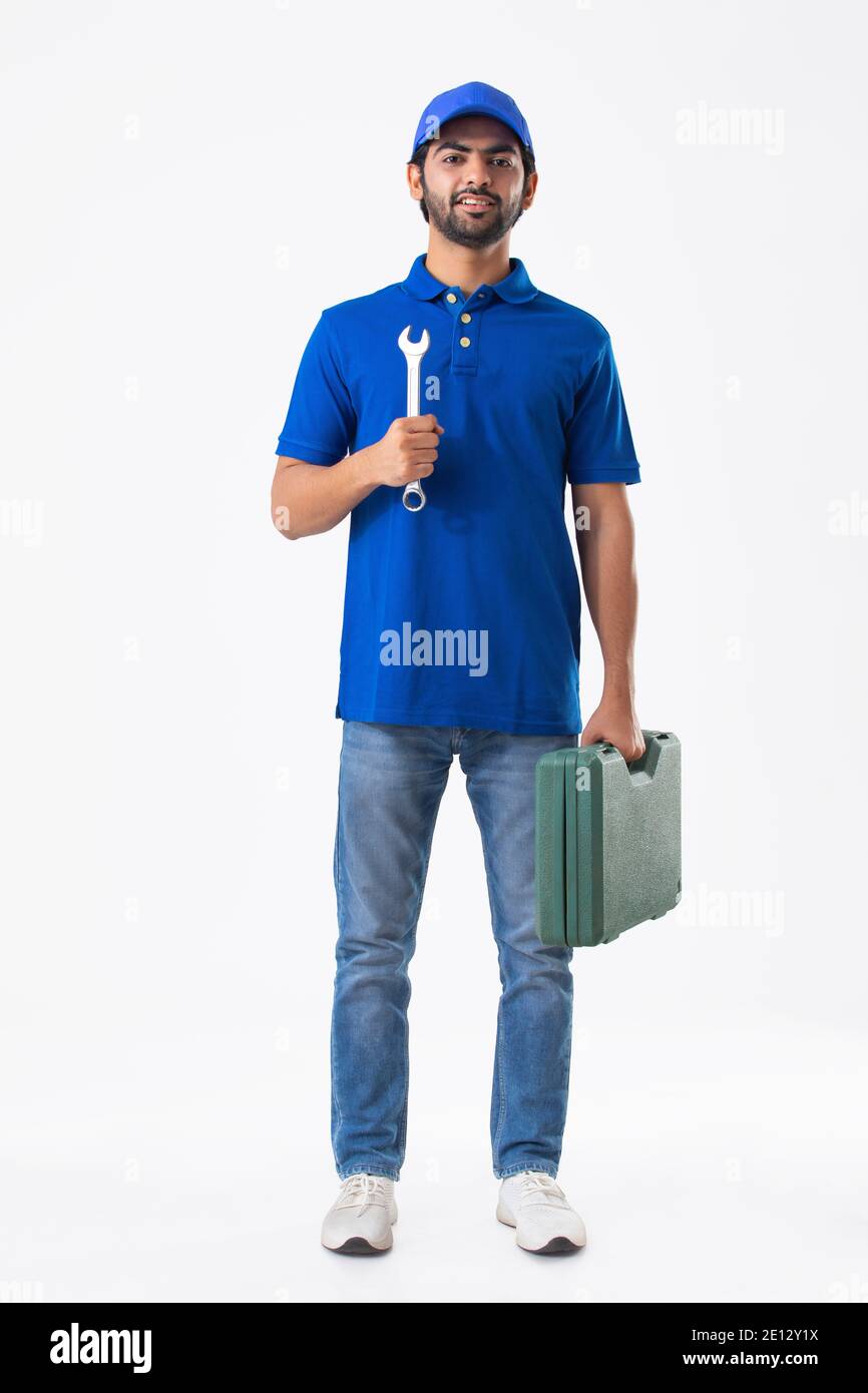A YOUNG PLUMBER STANDING WITH EQUIPMENT AND TOOLBOX Stock Photo