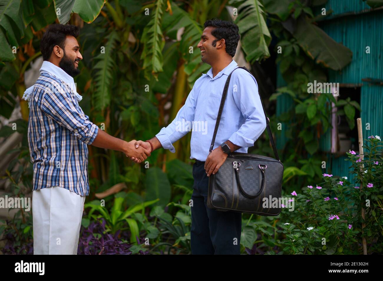 A VILLAGE MAN GREETING A SERVICE MAN WITH HANDSHAKE Stock Photo