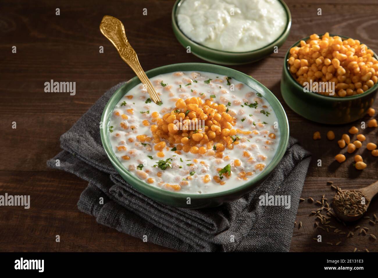 GARNISHED BOONDI RAITA SERVED ON A BOWL ALONG WITH RAW CURD AND SPICES Stock Photo