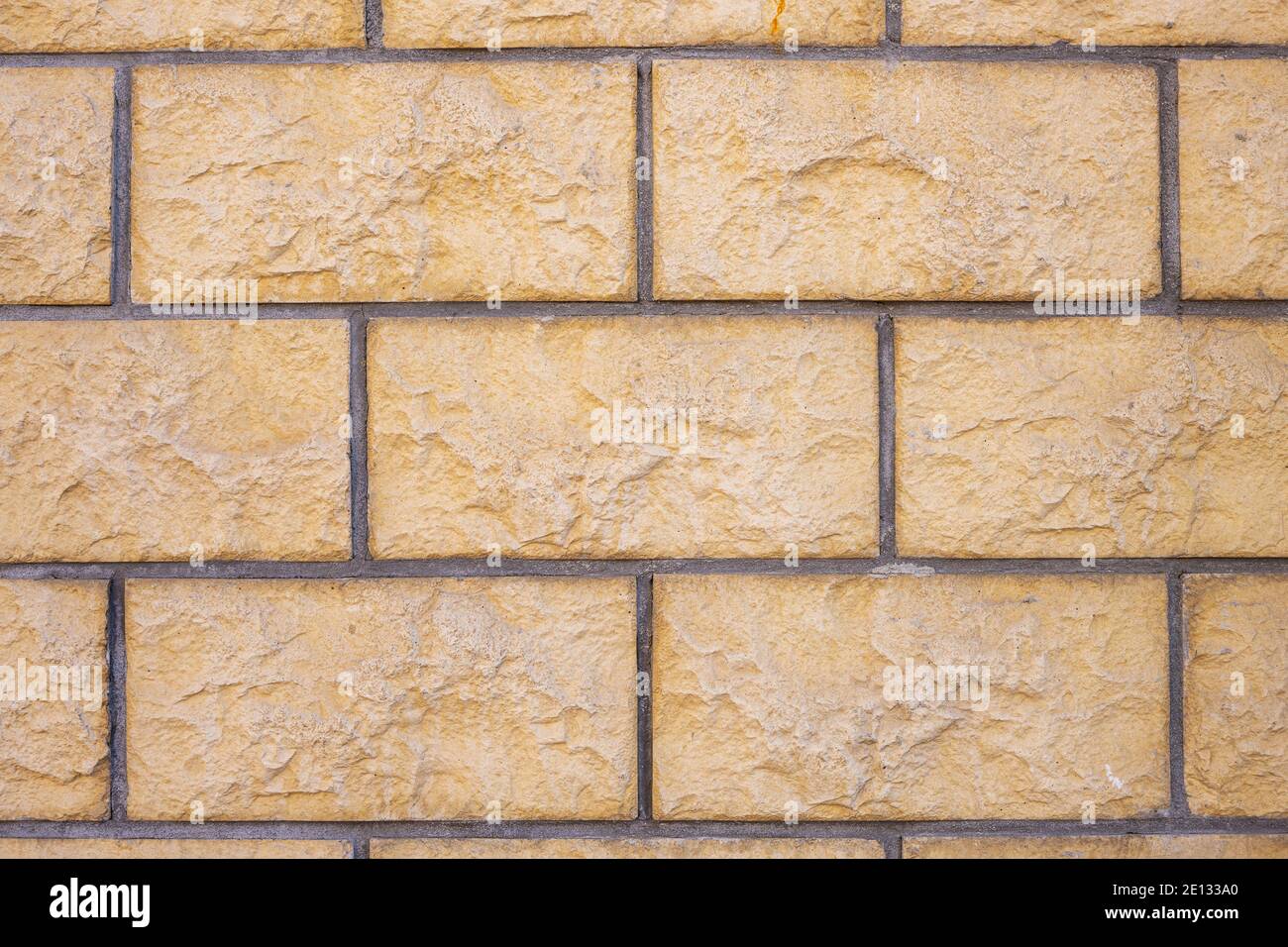 Background from a wall with beige block-shaped bricks Stock Photo