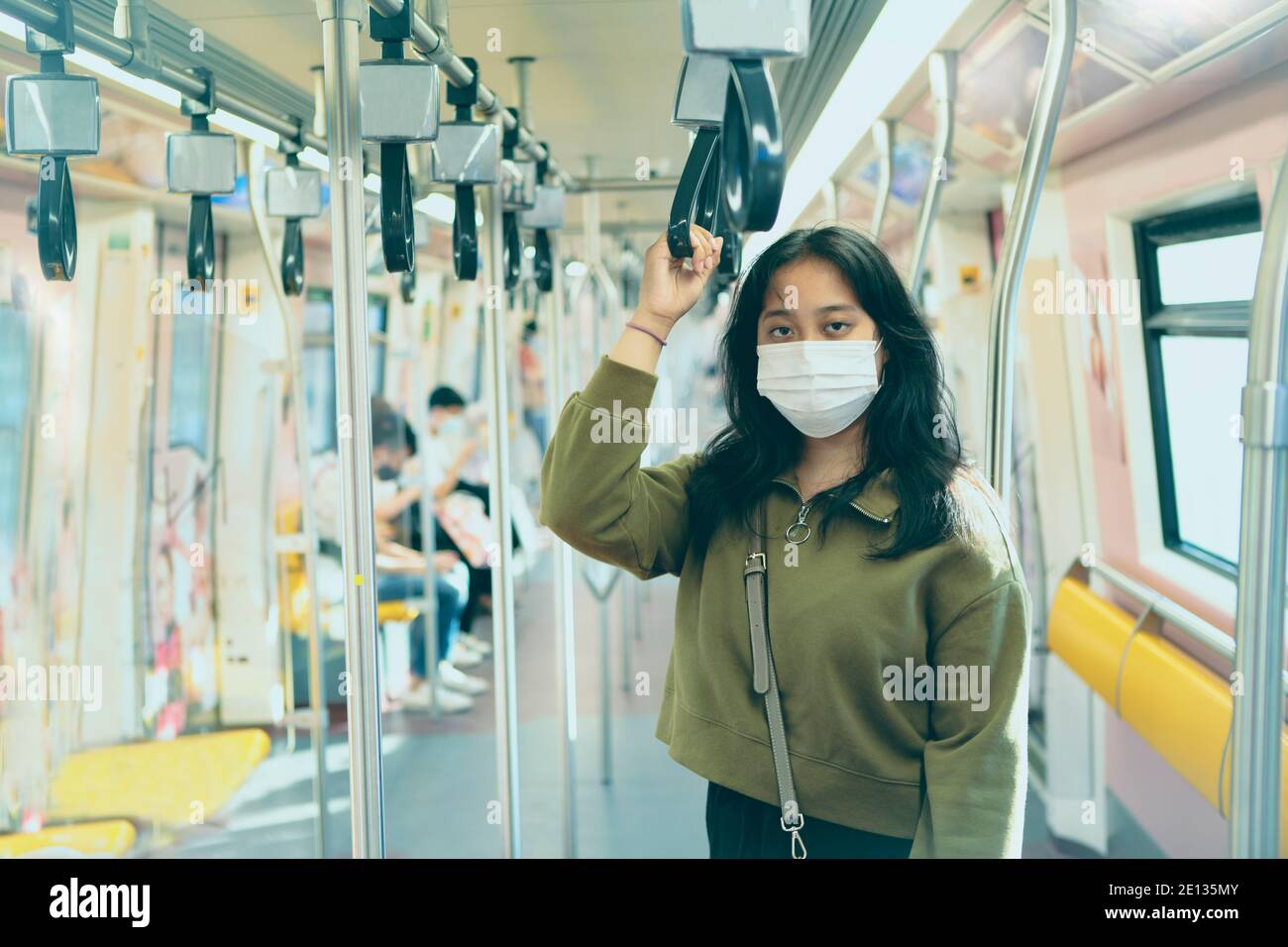 asian woman wearing protection mask standing in  city sky trains Stock Photo