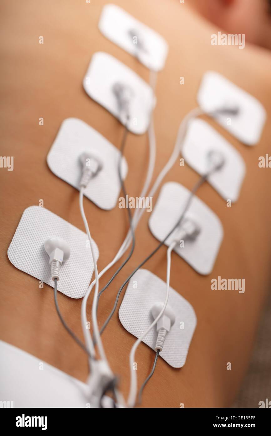 Electrode Stimulating massage of the spine at home. Medical procedure for muscle tone and beauty Stock Photo