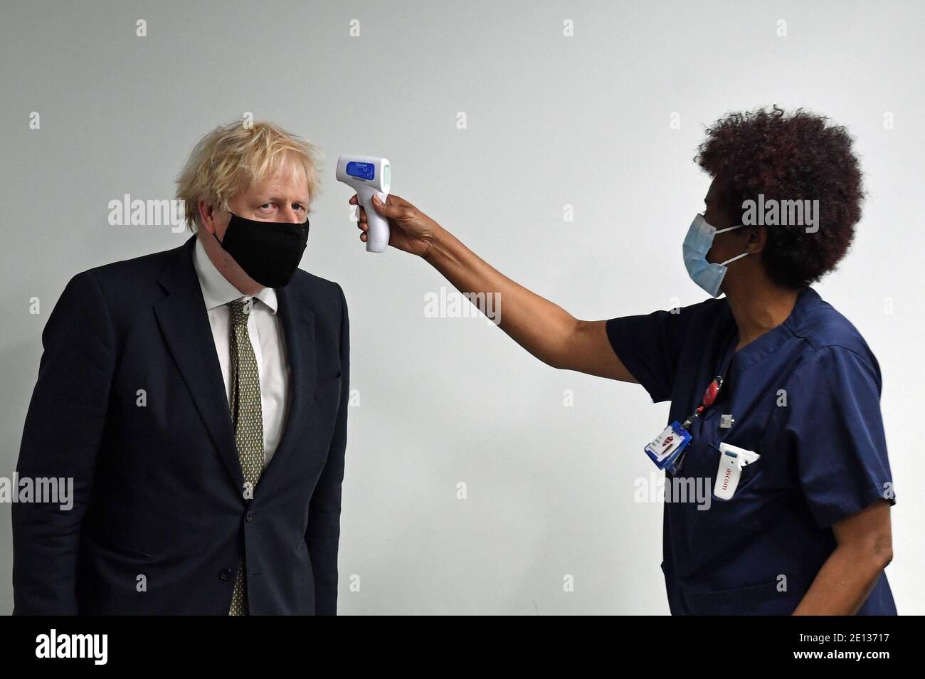 Prime Minister Boris Johnson has his temperature checked during a visit to Chase Farm Hospital in north London, on the day that the NHS ramps up its vaccination programme with 530,000 doses of the newly approved Oxford/AstraZeneca Covid-19 vaccine jab available for rollout across the UK. Stock Photo