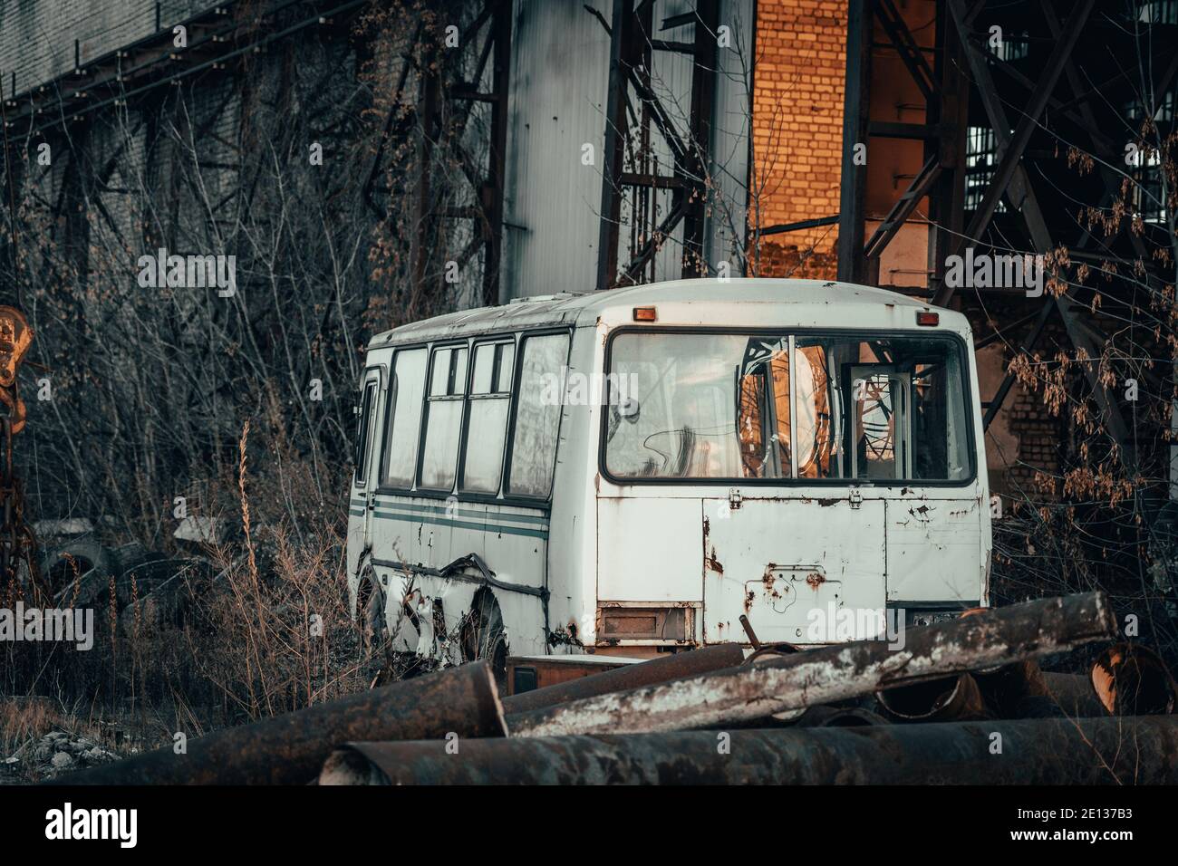 Old rusty broken abandoned bus in dark industrial post apocalyptic landscape. Stock Photo